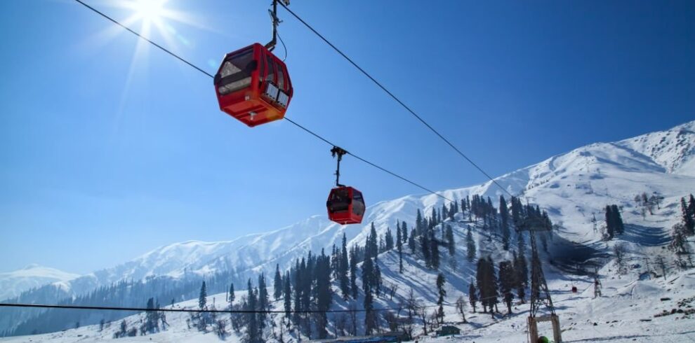 Red gondola cabins gliding over snow-covered slopes in Gulmarg – highlight of Gulmarg Luxury Trip