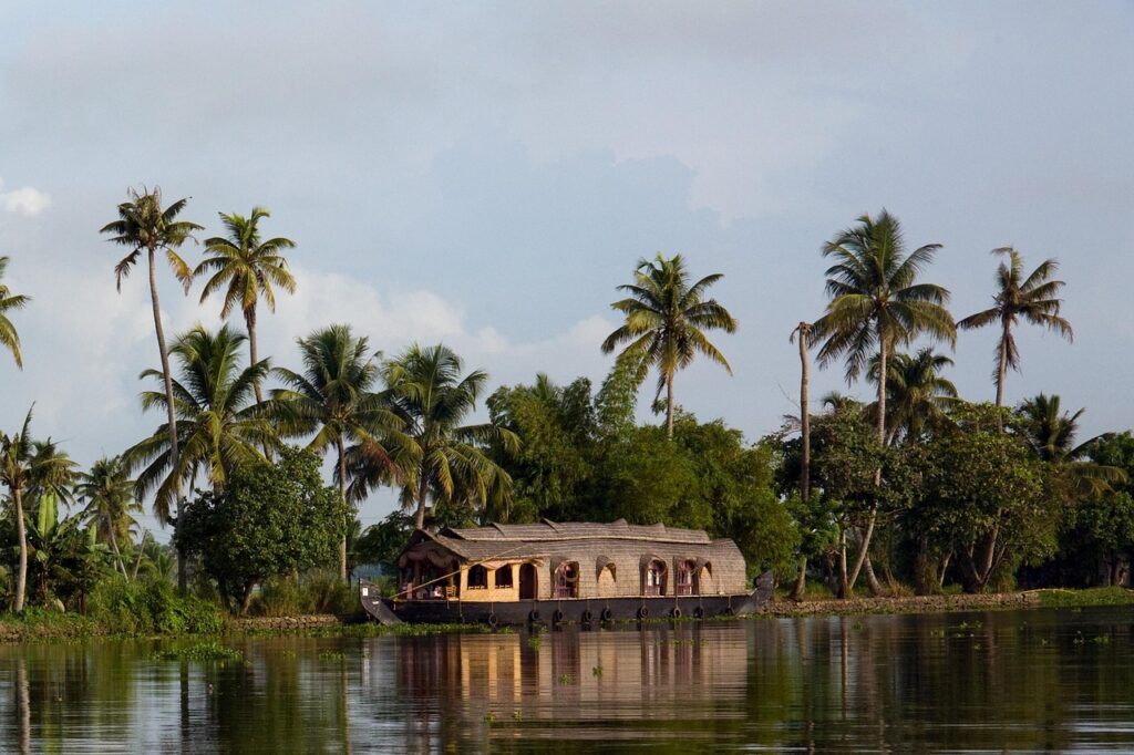 Kerala houseboat sailing along backwaters lined with palm trees – Kerala Luxury Trip