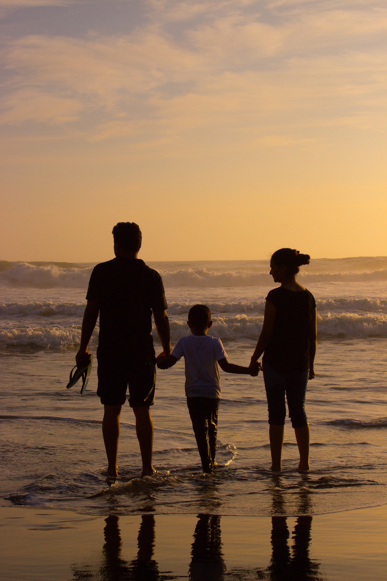 Family holding hands at the beach during sunset – Kerala Luxury Trip