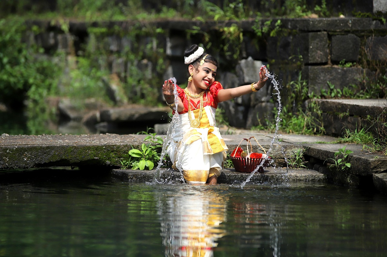 Girl in traditional Kerala attire playing near a village stream – Kerala Luxury Trip